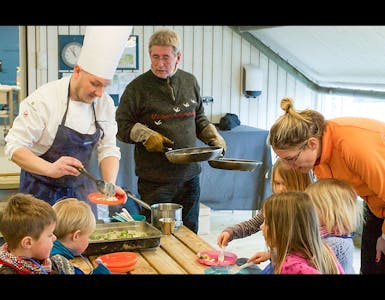 DET SERVERES: Her er Per Ivar Berget (i kokkeklær) og Arne Brimi i ferd med å servere nylaget mat til matglade barn. Foto: