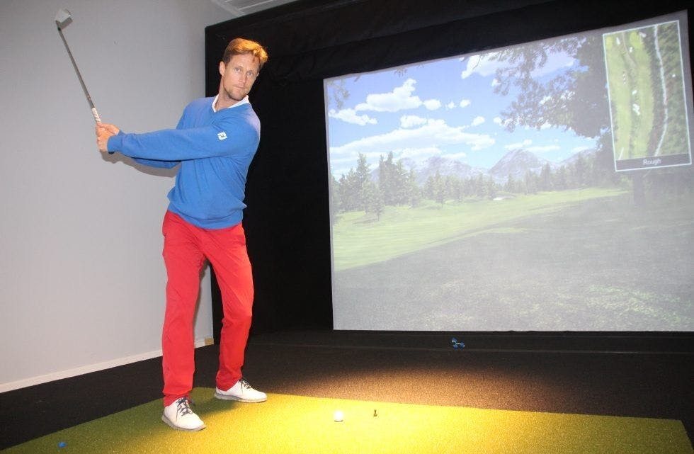 NYTT TILSKUDD: Hovedtrener Per Falk tester ut en av de to nye golfsimulatorene. Foto: