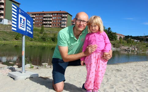 SKUFFET OG LEI: Årvoll-beboer Terje Marti har vokst opp rett ved Bjerkedalen park. Han og datteren Tuva (4) synes det er leit at de ikke kan ta i bruk den nye badedammen og at sandstranda bare skal være til pynt.  Foto: