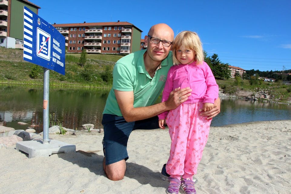 SKUFFET OG LEI: Årvoll-beboer Terje Marti har vokst opp rett ved Bjerkedalen park. Han og datteren Tuva (4) synes det er leit at de ikke kan ta i bruk den nye badedammen og at sandstranda bare skal være til pynt.  Foto: