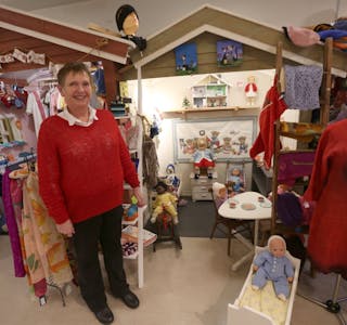 ET DUKKEHJEM: Erna Wold strikker blant annet klær til vanlige dukker og Barbiedukker. De stiller hun ut i Julehusets eget innredede dukkehus. Foto: