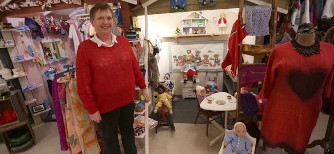 ET DUKKEHJEM: Erna Wold strikker blant annet klær til vanlige dukker og Barbiedukker. De stiller hun ut i Julehusets eget innredede dukkehus. Foto: