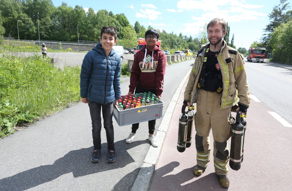UNGE HJELPERE: Richard (t.v.) og Mithun bor rett ved brannstedet og fikk med seg dramatikken. Etterpå hjalp de brannmann Runar Eide fra Sagene brannstasjon med å bære en bruskasse til tørste slokningsarbeidere. Som belønning ble det både brus og sjokolade til gutta. Foto: Rolf E. Wulff