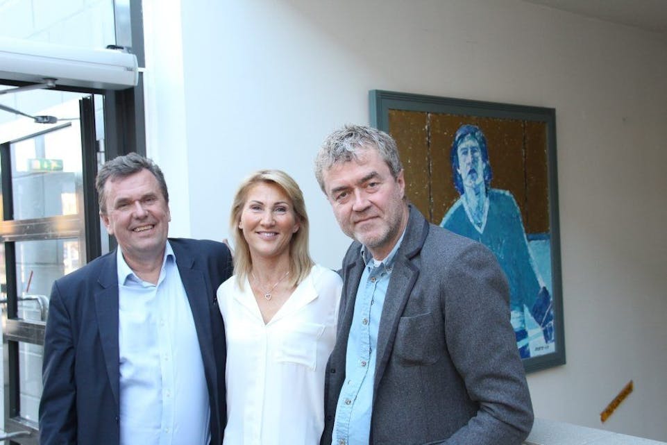 FORNØYDE: Bianca Skaare, omkranset av forfatterne Klaus Eriksen (t.h.) og Erik Throndsen. Bak ser vi Jon Thorstensens maleri av hockeylegenden. Foto: