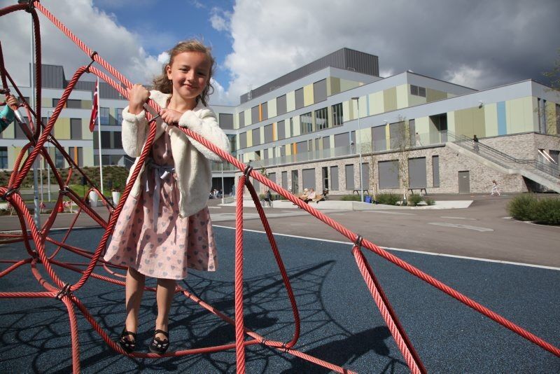 FORNØYD FØRSTEKLASSING: Julie (6) føler seg heldig som får gå på nye Vollebekk skole, og det tok ikke lang tid før hun prøvde ut skolens lekeapparater. Foto: