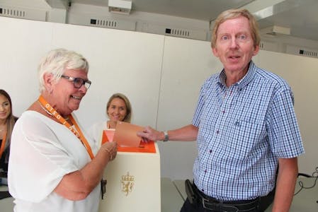 DA VAR DET GJORT: Bydelsutvalgsleder Knut Røli (Ap) i Alna bydel forhåndsstemte første dagen stemmelokalet åpnet. Her fikk han hjelp av stemmestedsansvarlig Marit Rønold. Foto: