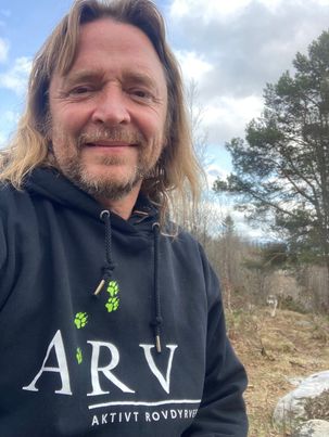 ALT FOR ULVEN: Helge Braathen er aktiv i lokalmiljøet, men også i organisasjonen Aktivt Rovdyrvern. I bakgrunnen av bildet kan du se en ulv. (FOTO: privat)