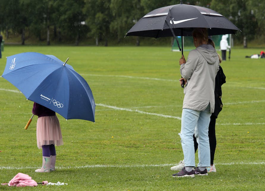 VIKTIG HJELPEMIDDEL: Det var mange som hadde sjekket værmeldingen og sørget for å bringe med seg paraply - og det fikk man god bruk for.