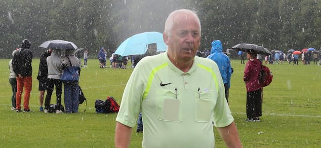 VÅT DOMMER: Når du har dømt Norway Cup i 25 tåler du litt regn - veterandommer Willy Furu tok det med et smil.