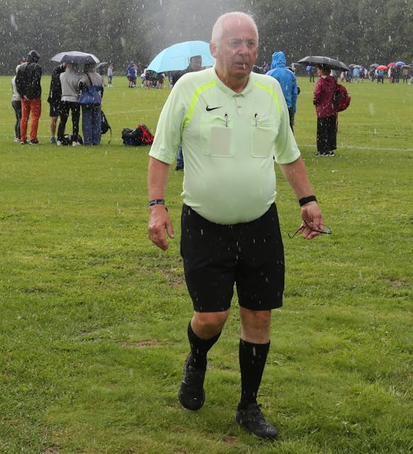 VÅT DOMMER: Når du har dømt Norway Cup i 25 tåler du litt regn - veterandommer Willy Furu tok det med et smil.