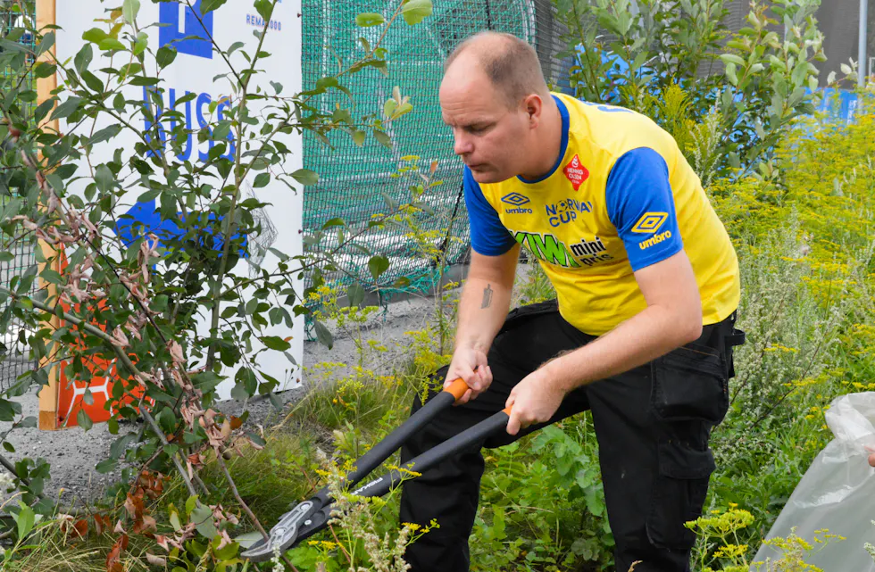 Tommy Løvlien rydder unna i buskveksten.