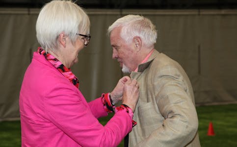 Statsforvalter Valgerd Svarstad Haugland festet fortjenstmedaljen på brystet til Thore Gjervig.