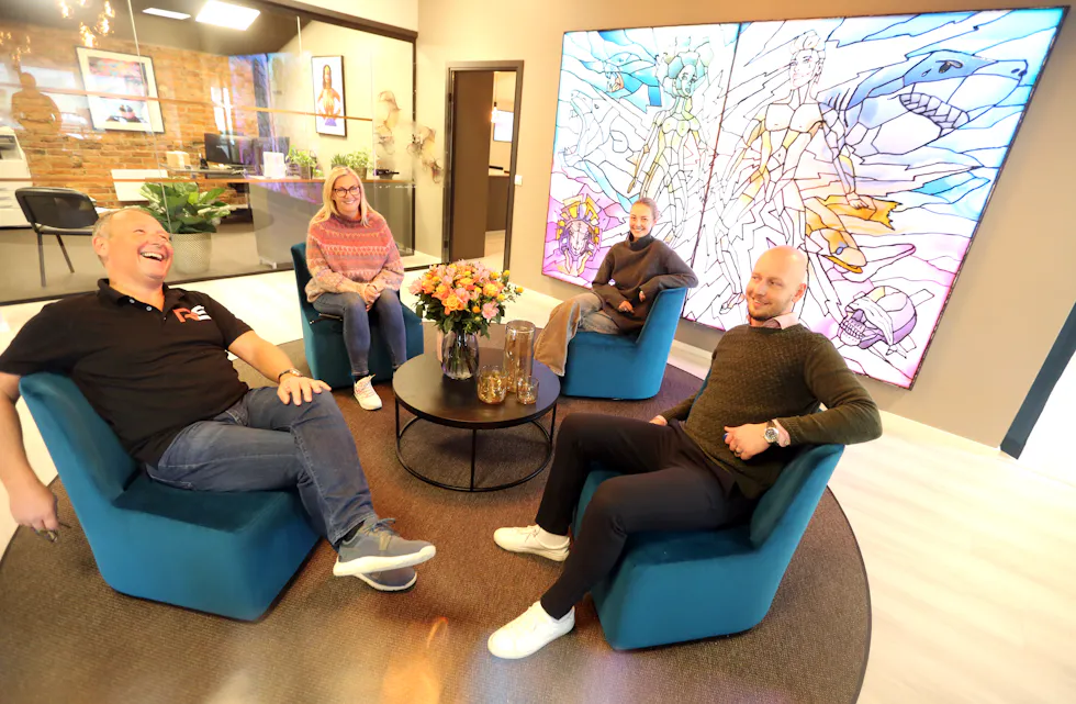 GODT HUMØR: Smilet er alltid på plass hos Rørlegger Sentralen. Innehaver Gunnar André Ludvigsen (f.v.), markedsansvarlig Gry Ludvigsen, regnskaps og markedsføringskoordinator Andrea Ludvigsen og daglig leder Anders Berge slapper av i den koselige resepsjonen med NiX sin lysende mosaikkunst på veggen.