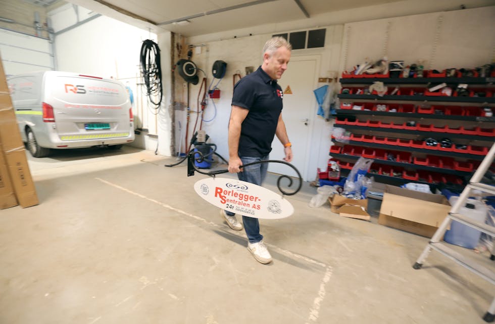 PÅ FLYTTEFOT: Teknisk sjef Einar Kjus sørger for at firmaskiltet kommer på plass i de nye lokalene - her for øvrig i garasjeanlegget.