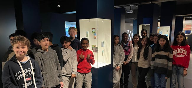 TEAMWORK: Elever fra Lindeberg skole står ved siden av bildene de har laget til kunstutstillingen «ENERGI i klimakrisens tid»