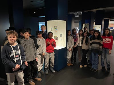 TEAMWORK: Elever fra Lindeberg skole står ved siden av bildene de har laget til kunstutstillingen «ENERGI i klimakrisens tid»