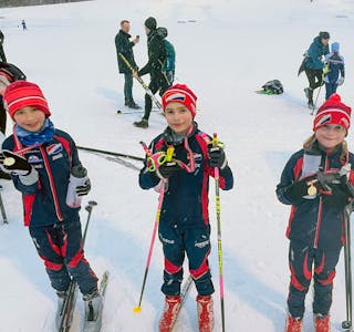 Emil (8), Luca (8) og Nomi (8) viser stolte fram medaljen og beviset på at de fullførte dagens renn. De forteller at skicrossen var en suksess, men at det aller morosmste var å passere så mange i løypa.