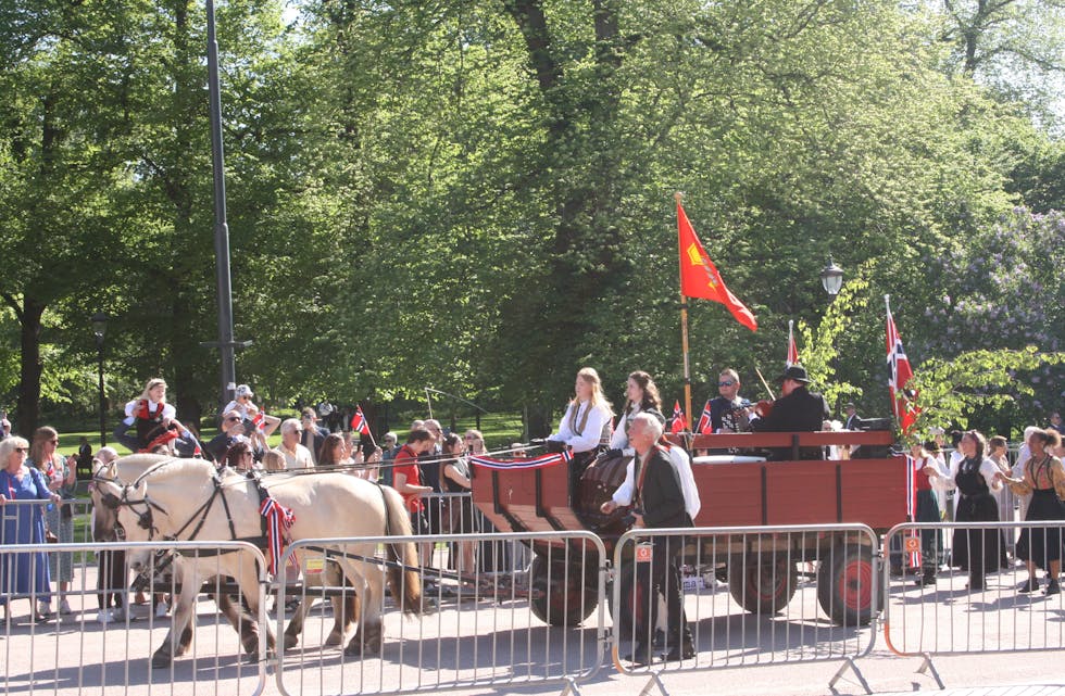 VARMET OPP PUBLIKUM: Før barnetoget startet, fikk publikum varme opp da hest og kjerre med folkedansere etter seg tok turen nedover.