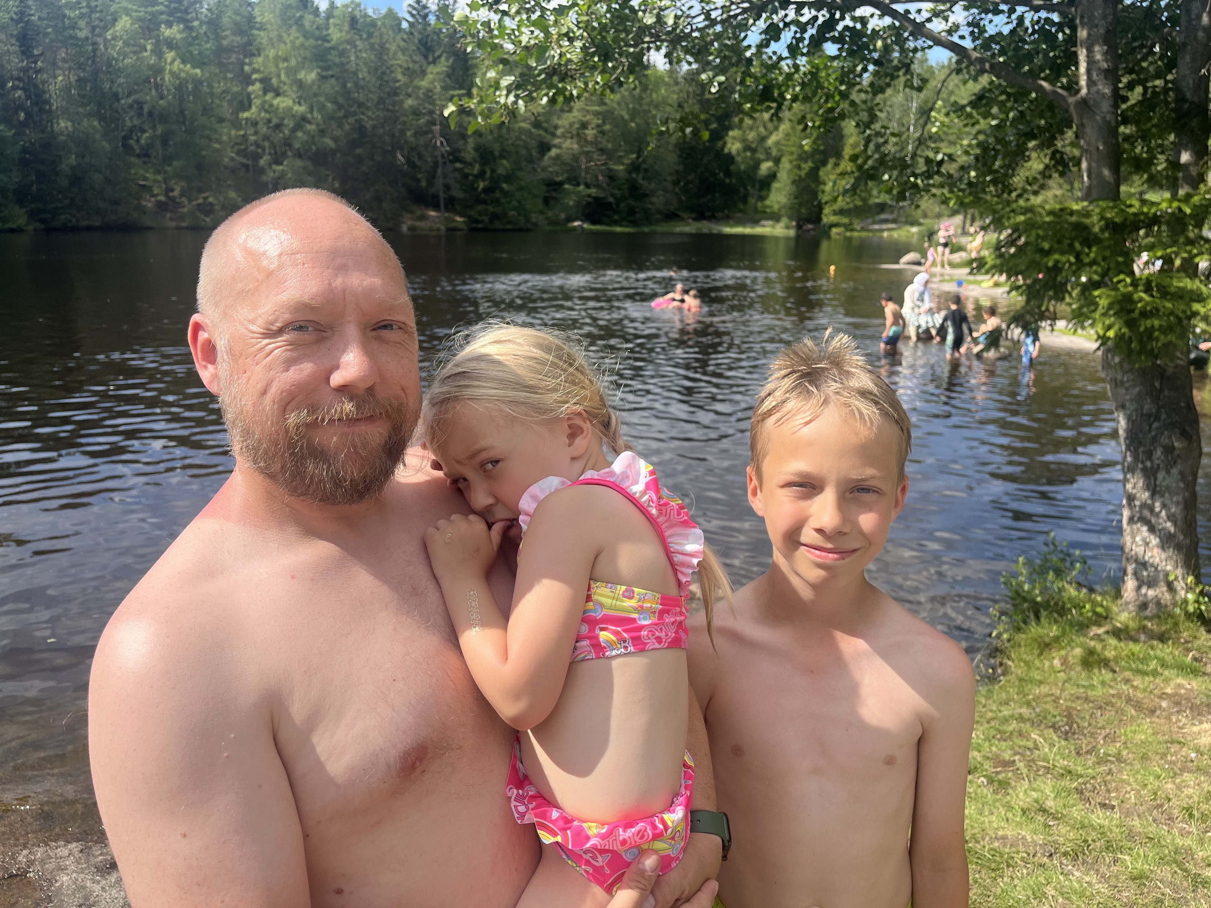 Pappa Jan Helge (f.v), Eira og Gard nyter sola maksimalt på Badedammen.