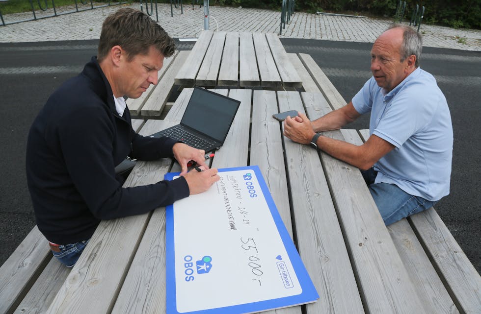 SKRIVEGLAD SPONSORSJEF: Rasmus Aarflot skriver ut en sjekk på kroner 55.000 til styreleder Jon Schmidt i Høybråten og Stovner IL.