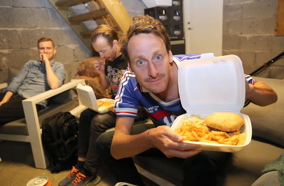 NØDVENDIG PAUSEFØDE: Hamburger og pommes frites. Det skal spises godt mellom fotballomgangene i garasjen til Christophe. Magnus (tv) og Mikael er enige.