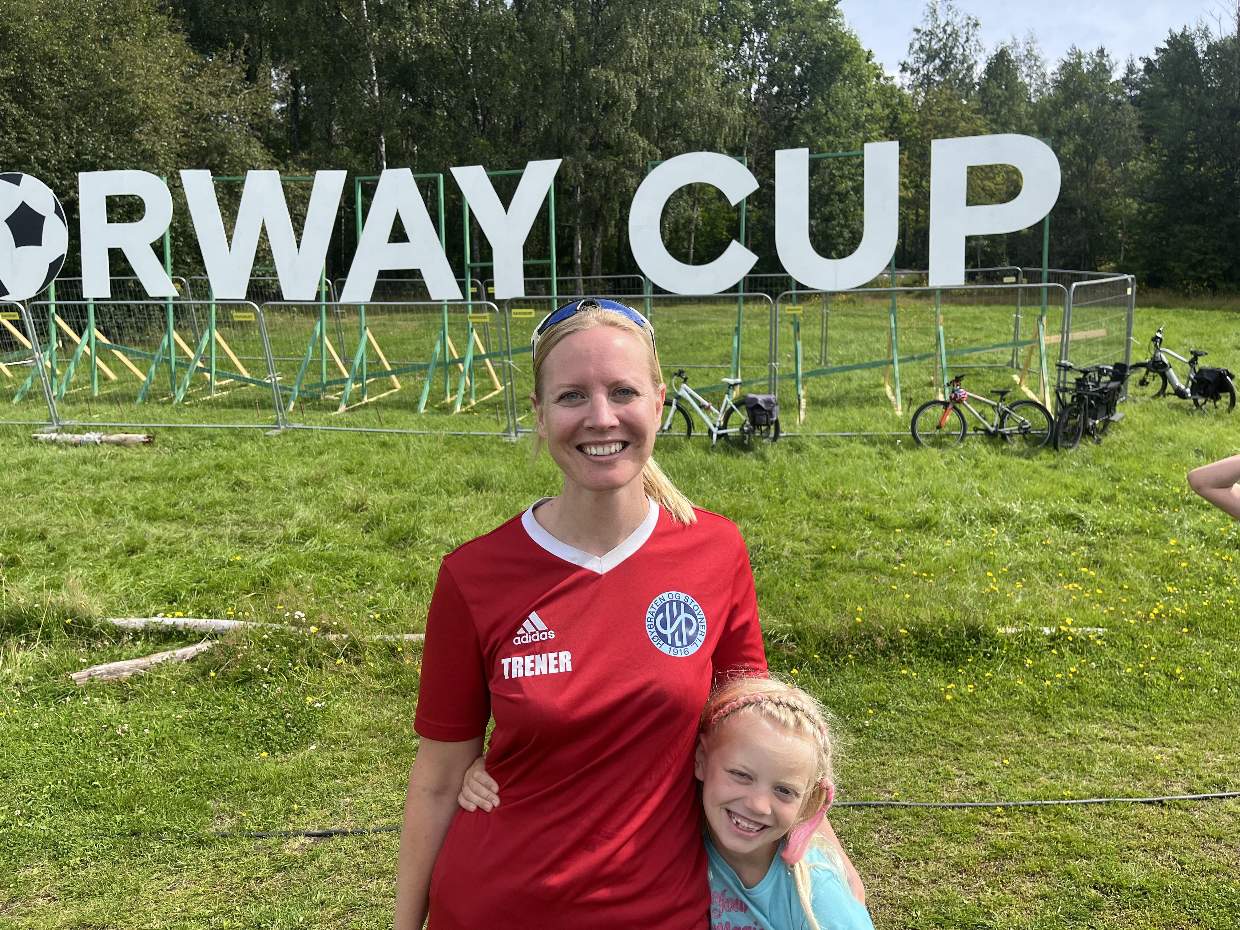 TRENERROLLEN GÅR SMERTEFRITT: Her står Ingeborg Kjendlie med hennes datter – og lagets maskot. En bedre gjeng å ta med seg på Norway Cup enn hennes spillere, kunne ikke Kjendlie bedt om.