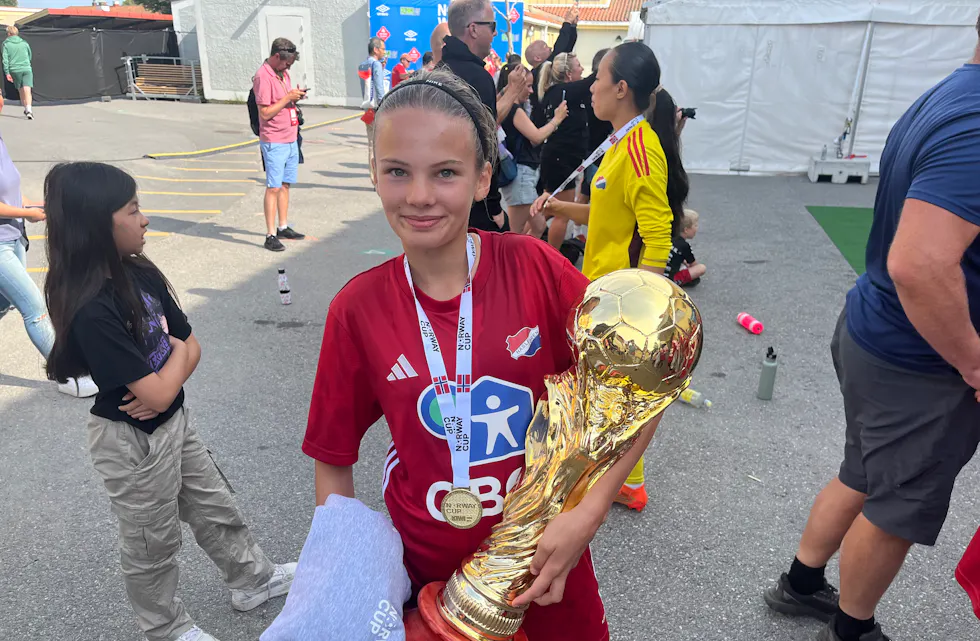 GIGANTPOKAL: Du vet du har levert varene når du står med en pokal, nesten like stor som deg selv. Avbildet er lagets kaptein, Iselin Hamnvik, som regjerte på midtbanen.