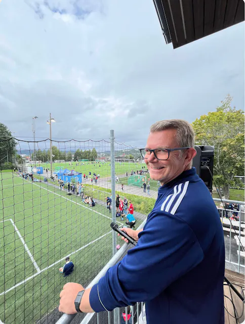 Håvard Braserudhaget, leder for HSIL fotball, står og nyter synet av all fotballgleden han ser fra det splitter nye klubbhuset.