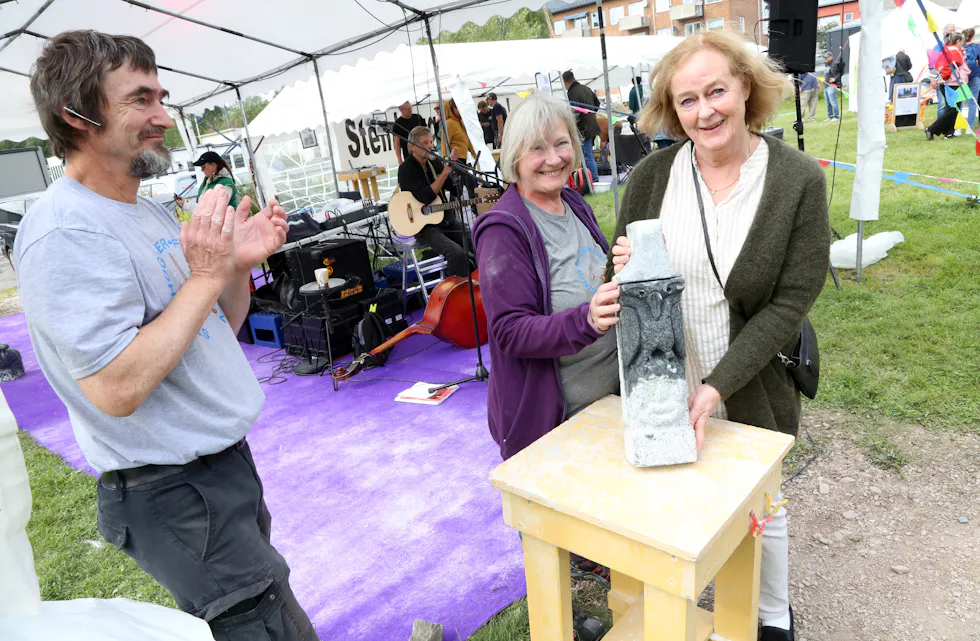 HELDIG VINNER: Berit Solberg fra Vestli ble den heldige vinneren av denne skulpturen laget av Chris Fleurie - trukket ut blant dem som kjøpte lodd under Steinhoggerfestivalen. Jan Lange og Frøydis Arnesen gratulerer.