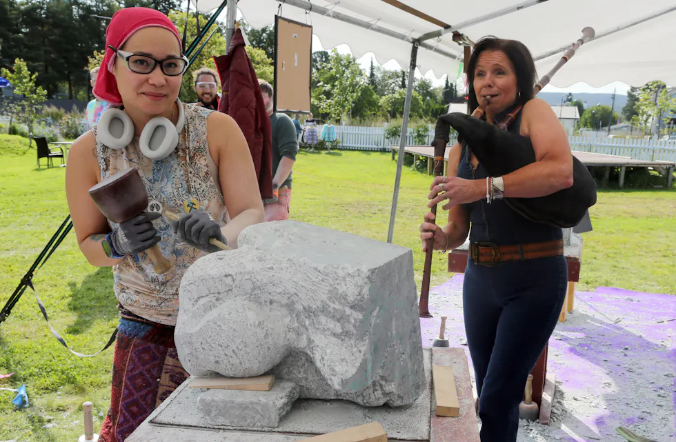 MUSIKK TIL ARBEIDET: Det er første gang steinhogger «Scotty» har opplevd å bli akkompagnert av sekkepipemusikk til hoggerarbeidet - det sørget Elisabeth Vatn for.