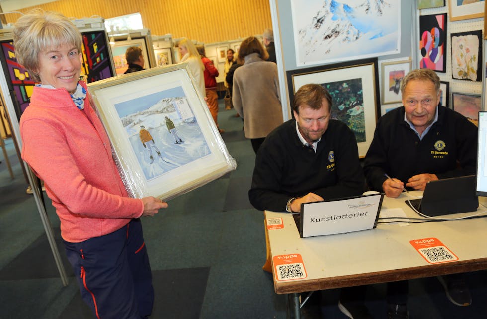 PERFEKT BILDE: Gunvor Brekken var svært fornøyd da hun fikk kjøpt dette maleriet med motiv fra Golsfjellet hvor hun selv er fra og hvor hun har stått på ski mange ganger. Maleriet skal henge på hytteveggen på Beitostølen. Bak bordet sitter Arnfinn Rung (t v) og Bjørn Holm som solgte kunstlotteri til inntekt for Sykehusklovnene.