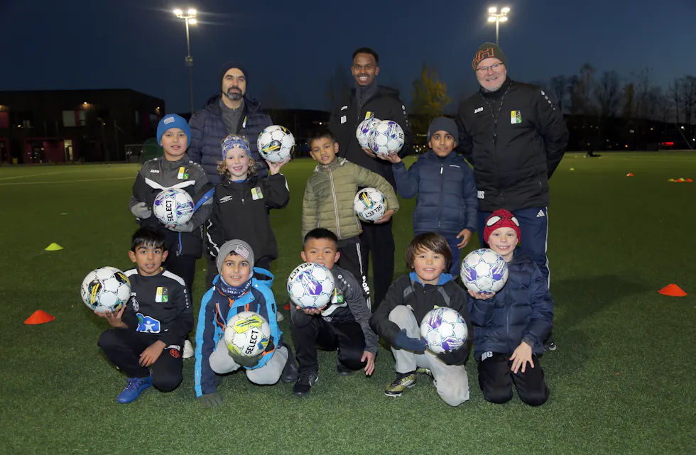 HÅPEFULLE SPILLERE: Trenerene Mohammed Mohammady (f v) og Ridwan Ahmed, samt administrerende leder for fotballakademiet i Veitvet SK, Kåre Magne Stennes, sammen med en gjeng blide fotballspillere på Veitvetbanen.
