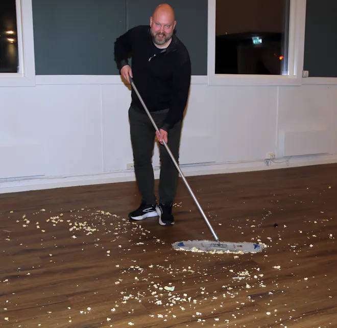 KLASSISK OPPRYDNING: Popcorn og kino hører sammen - men det krever popcornopprydning etter forestillingen. Det tar popcornsjef Ingolf Sjøberg seg av med en stor kost og et smil.