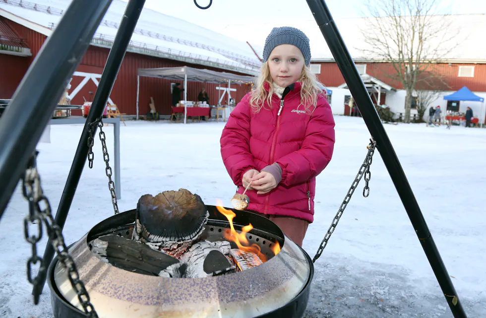 VARME GODBITER: Olivia (6) varmer opp en marshmallow over bålpanna på gårdstunet - akkurat slik som rampenissen gjorde det om natta hjemme hos henne - han brukte for øvrig peisen.