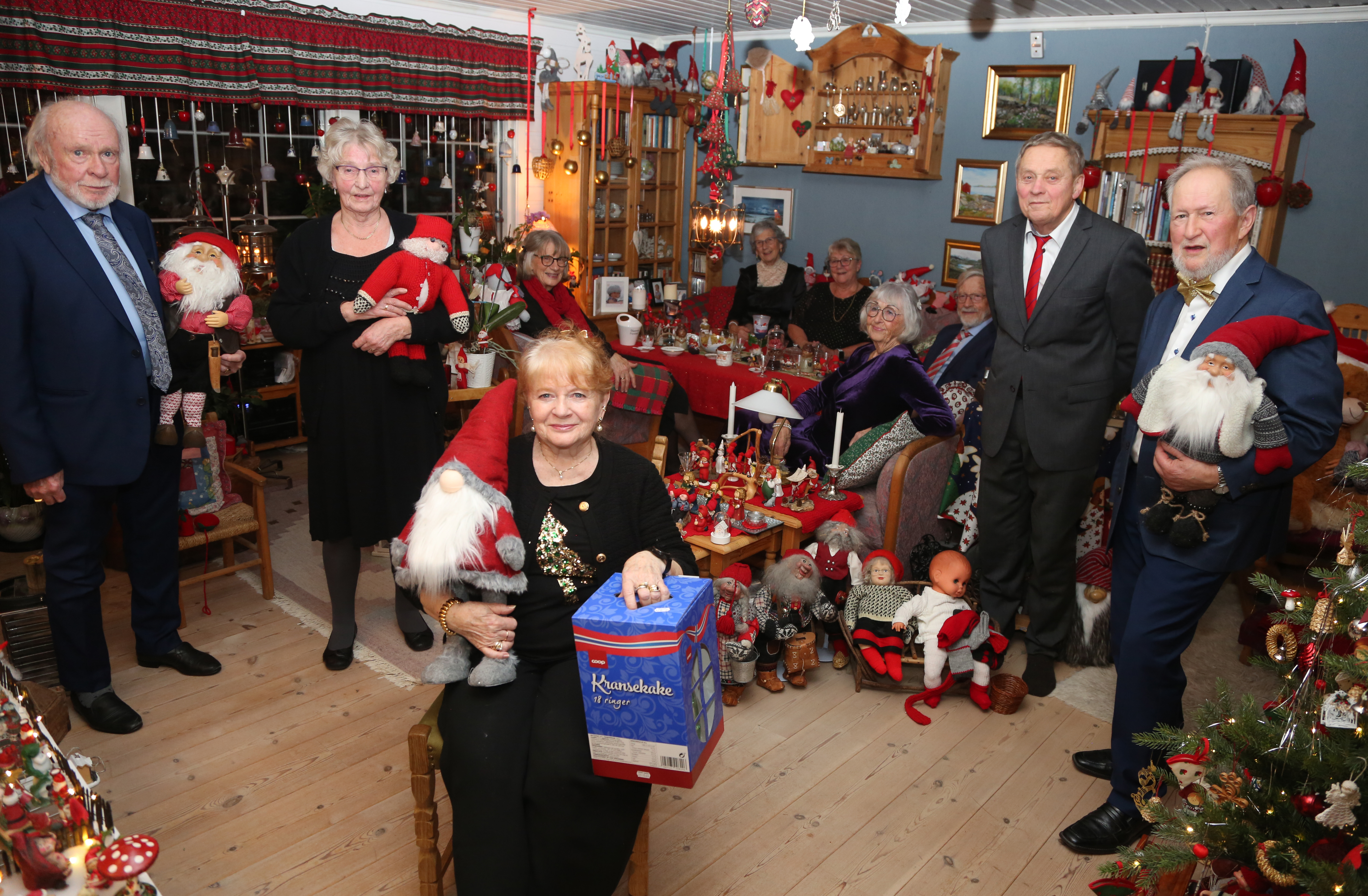 BLANT NISSENE: Når det skal fotograferes i stua til Frøydis og Gunnar på nyttårsaften, bringes festdeltakerne selvfølgelig inn i nisseland. Vidar Cederkvist (f. v.), Grete Paulsen, Trina Rudi, Lut Sercu, Evy Gahrmaker, Guttorm Rudi, Laila Tjemsland, Bjørn Erik Paulsen og Gunnar Stenerud. Frøydis Cederkvist Stenerud sittende i forkant.