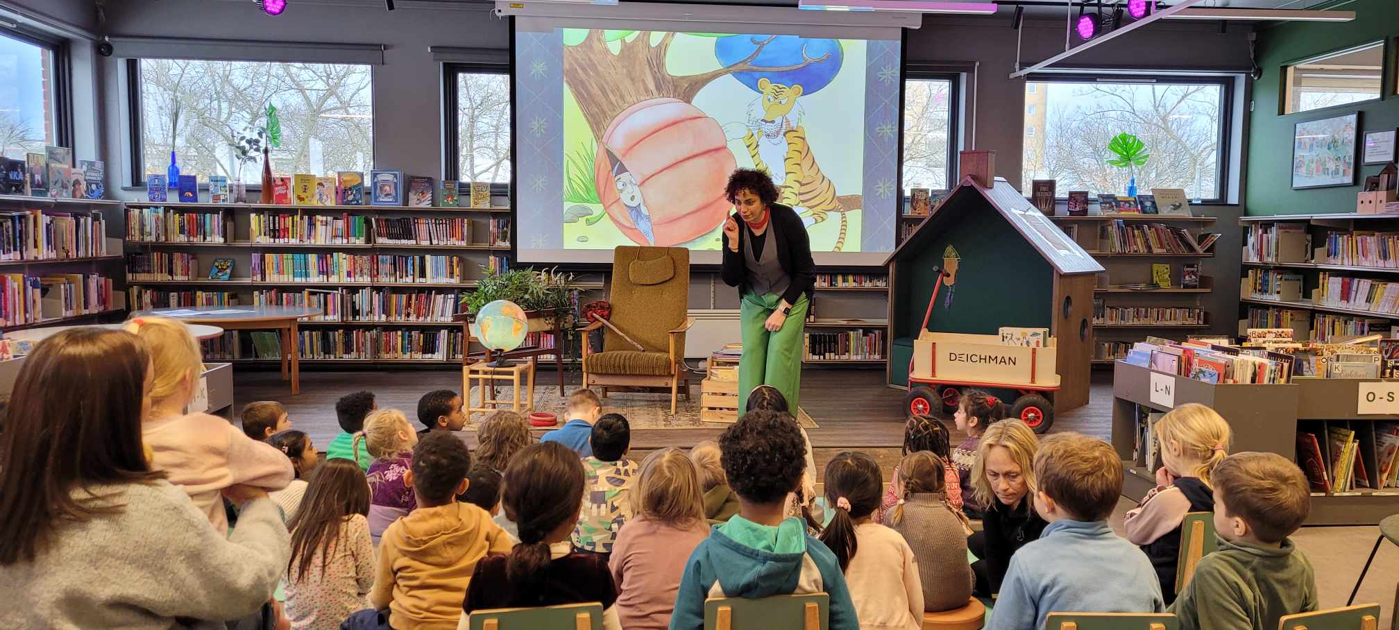 FEIRET SPRÅK: Barn og voksne samlet seg på Deichman Nordtvet for å feire morsmålsdagen med fortellinger, dikt og sanger på flere språk. Her med Parichehr Taheri på scenen foran engasjerte barn.