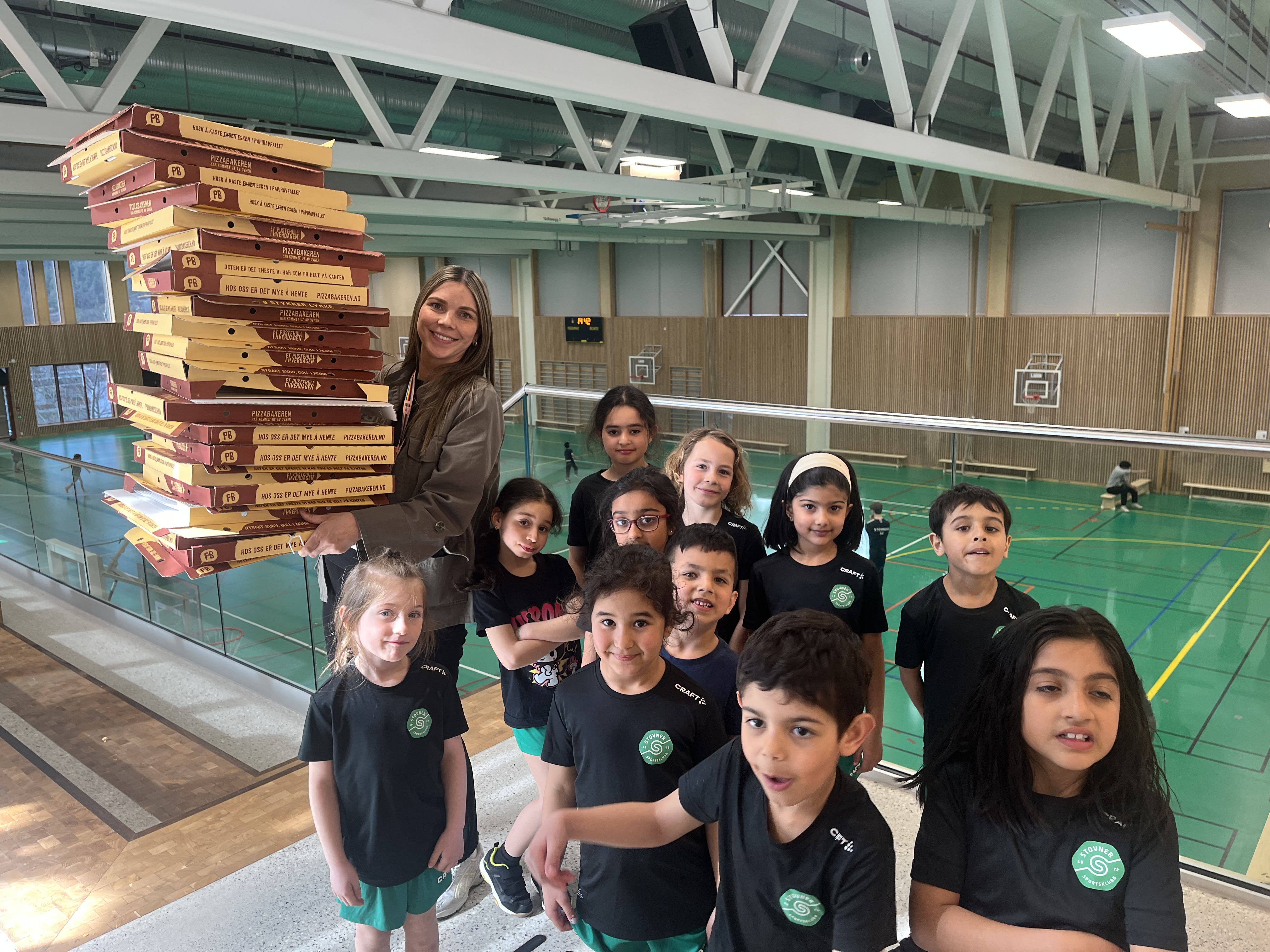 PIZZAFEST: Malin Knutsen, leder for AKS på Vestli, sammen med noen av AKS-barna etter en enorm pizzafest.