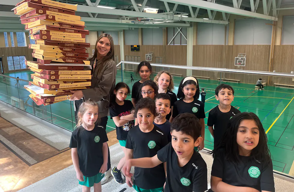 PIZZAFEST: Malin Knutsen, leder for AKS på Vestli, sammen med noen av AKS-barna etter en enorm pizzafest.