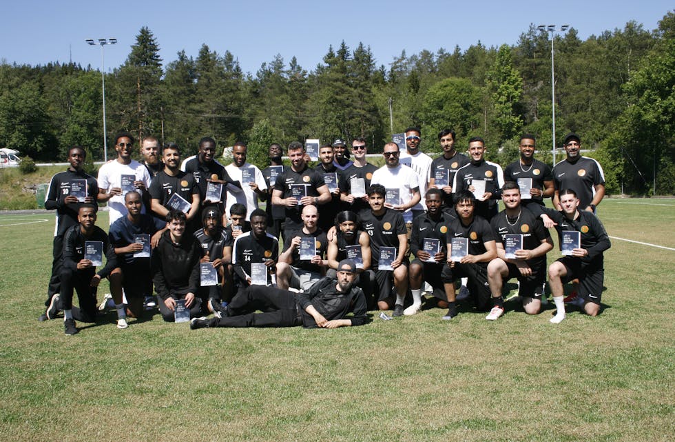 HYLLER GJENGEN: Don Martin (liggende foran) overraska Romsås IL A-laget med personlige hilsninger og bok til samtlige spillere, som takk for den innsatsen de gjør ikke bare på banen, men for hele Romsås.