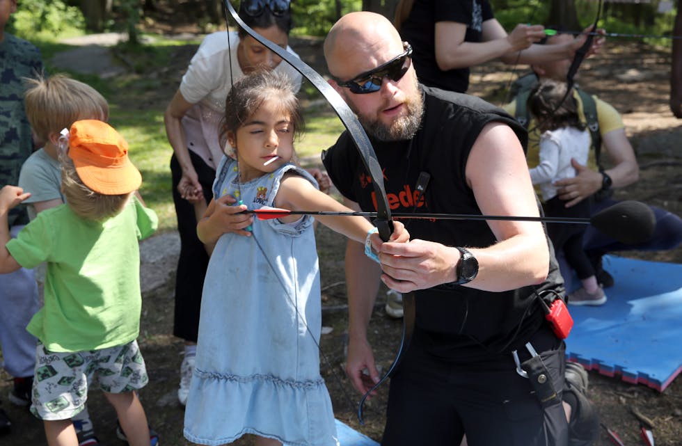 FULL KONSENTRASJON: Med kjærlighet i munnen og et lukket øye håpet denne jenta på å treffe blinken med pil og bue.
