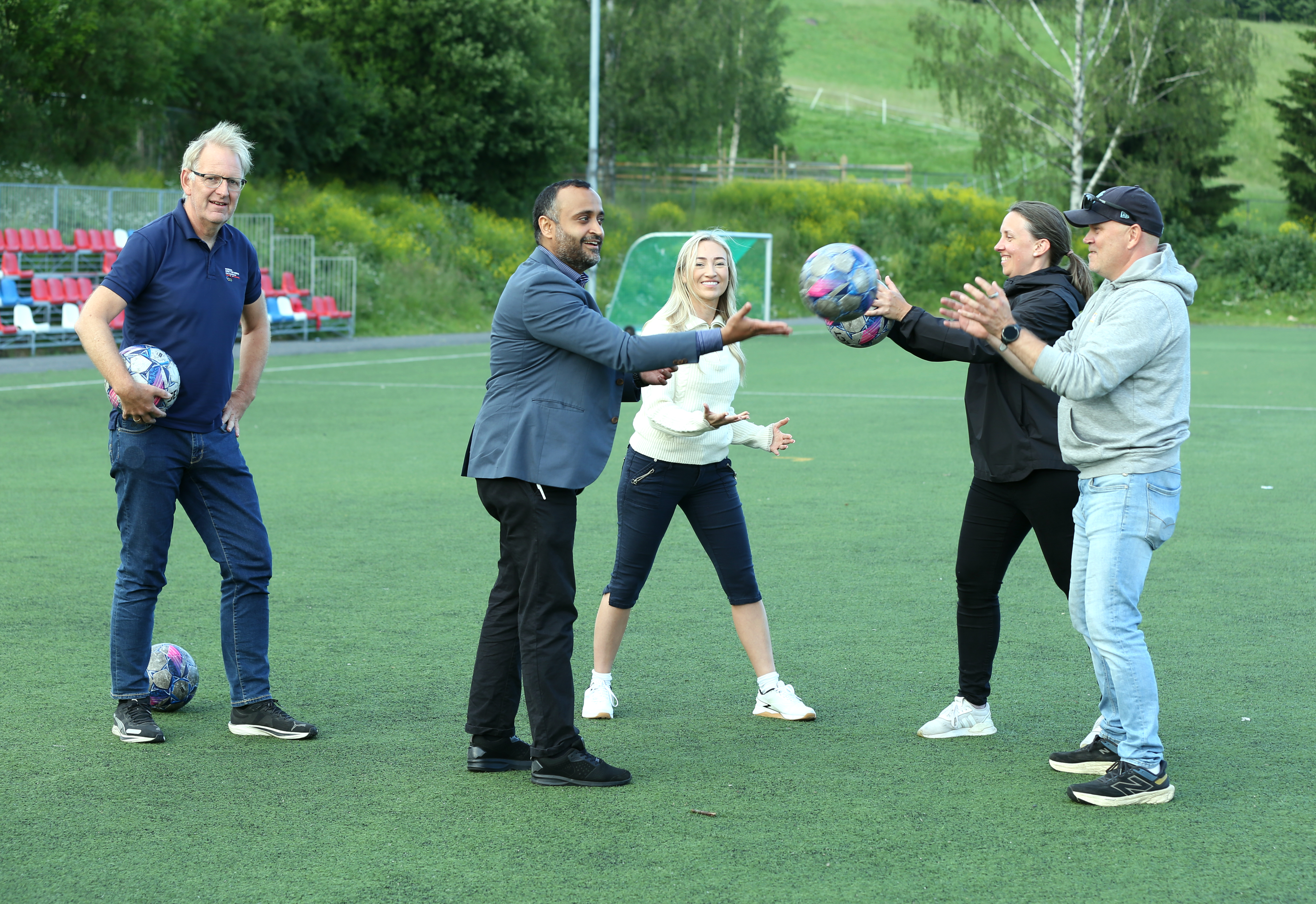 SYMBOLSK OVEREKKELSE: De kom ikke med cash, men med lovnad om at Årvoll IL vil bli bevilget 11,5 millioner kroner til undervarme på banen – men en symbolsk balloverrekkelse ble gjennomført – med generalsekretær i Oslo Idrettskrets, Magne Brekke, som fornøyd overvåker.