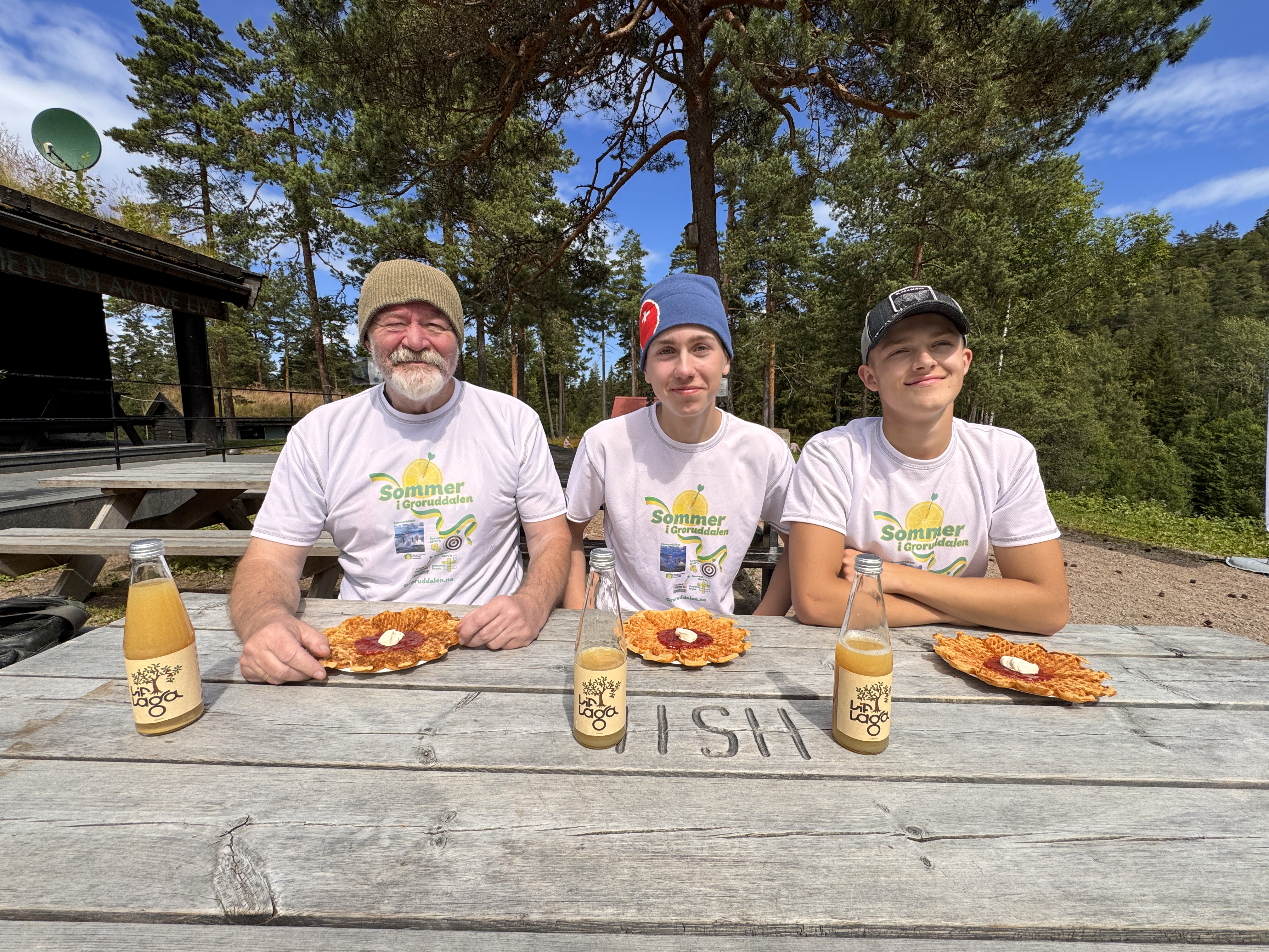 Wulff, Martin og Endre har fått servert de mye omtalte eplevaflene på Liastua, og er klare for å smake herligheten. Det er Líf Laga som står bak oppskriften, stekingen og serveringen - og har også utstyrt smakspanelet med eplemosten presset av epler fra nærområdet. Foto: Øystein Kielland