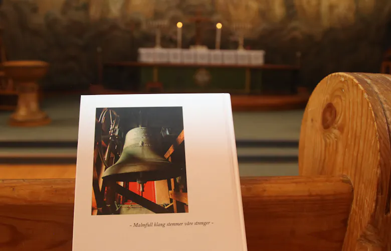 SKAL RINGE: Et bilde av kirkeklokka i Grorud kirke pryder baksiden på boken om Grorud kirkes historie. Til torsdag skal den kime i solidaritet for befolkningen i Gaza.