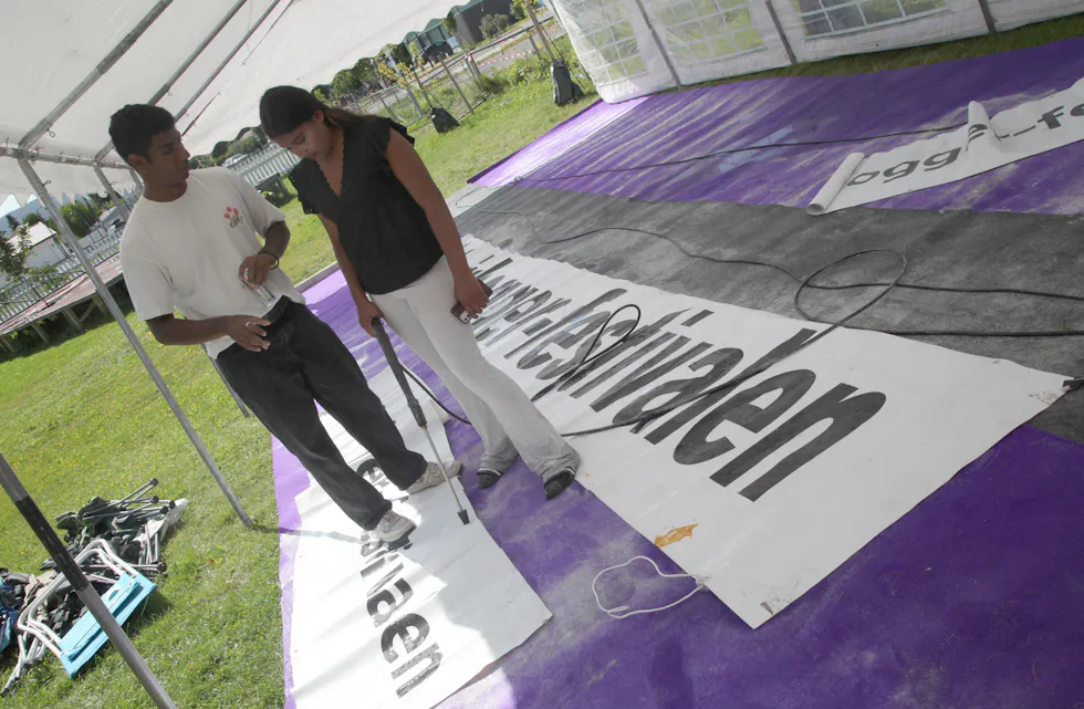 RENE BANNERE: Sanjay (20) gir instrukser til Haleema (14) om hvordan vannspyleren skal tas i bruk. Alle bannere skal være skinnende rene når steinhoggerfestivalen settes i gang.