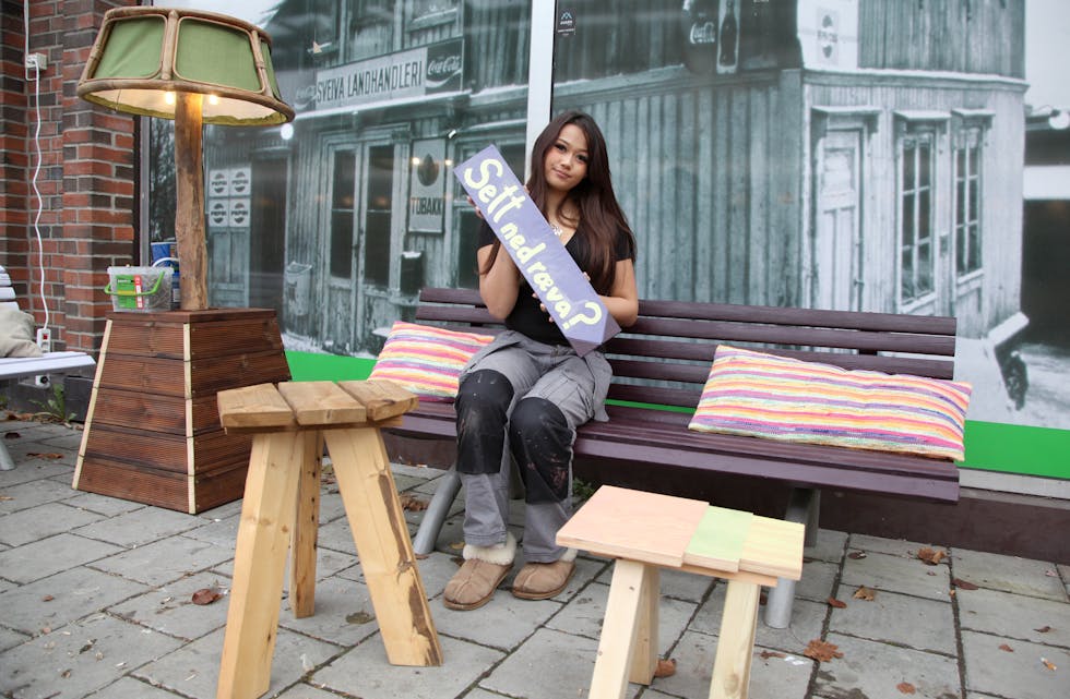 GOD ARBEIDSERFARING: Karoline N. Myhr (17) har tatt seg en pause i utdannelsen, men synes det er viktig å benytte den tiden til å få arbeidserfaring. Nå er hun en av spirene i Spireverket. Her ved kosekroken på Ellingsrud torg hvor hun viser fram en av de fantasifulle skiltene som nå skal prege torget.