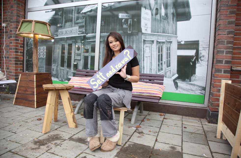 GOD ARBEIDSERFARING: Karoline N. Myhr (17) har tatt seg en pause i utdannelsen, men synes det er viktig å benytte den tiden til å få arbeidserfaring. Nå er hun en av spirene i Spireverket. Her ved kosekroken på Ellingsrud torg hvor hun viser fram en av de fantasifulle skiltene som nå skal prege torget.