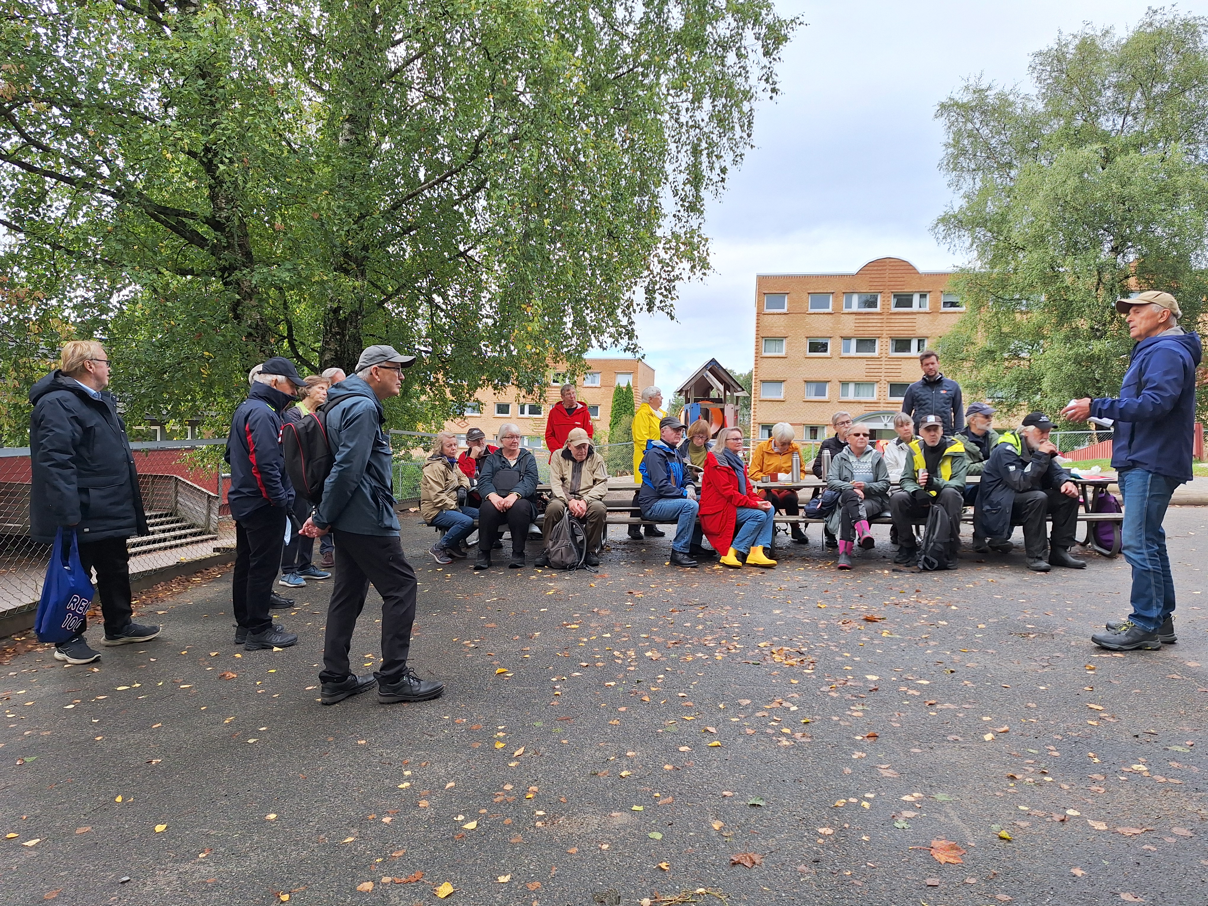 Turgåerne under rasten på Sandbakken. Tor Paulsen fortalte og viste fotografier fra området og den gamle Linderud skole, der han vokste opp. Foto: Anne Fikkan