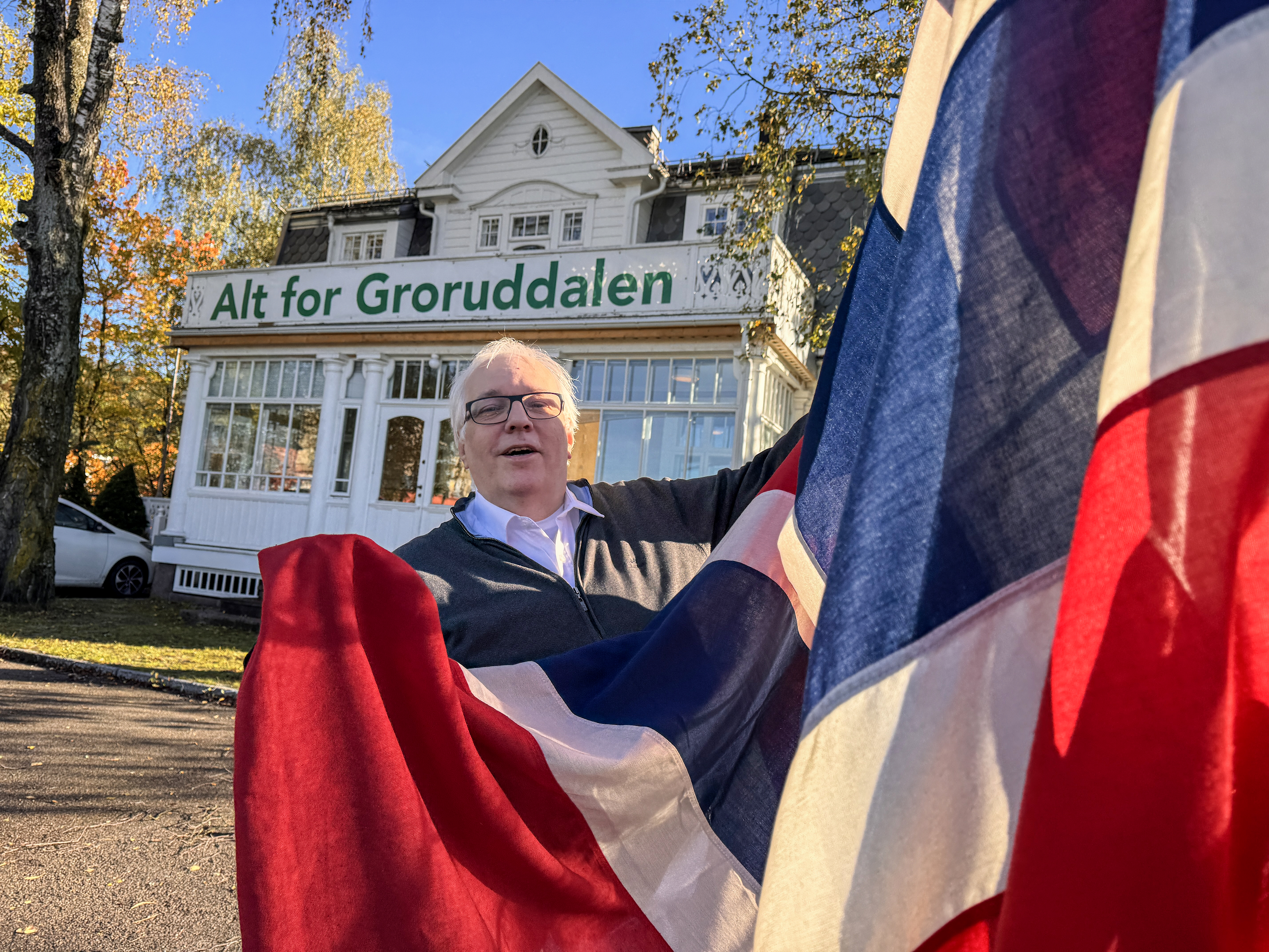 Redaktør Hjalmar Kielland jr heiser flagget foran avishuset på Grorud i anledning 65-årsmarkeringen for Groruddals-begrepet.