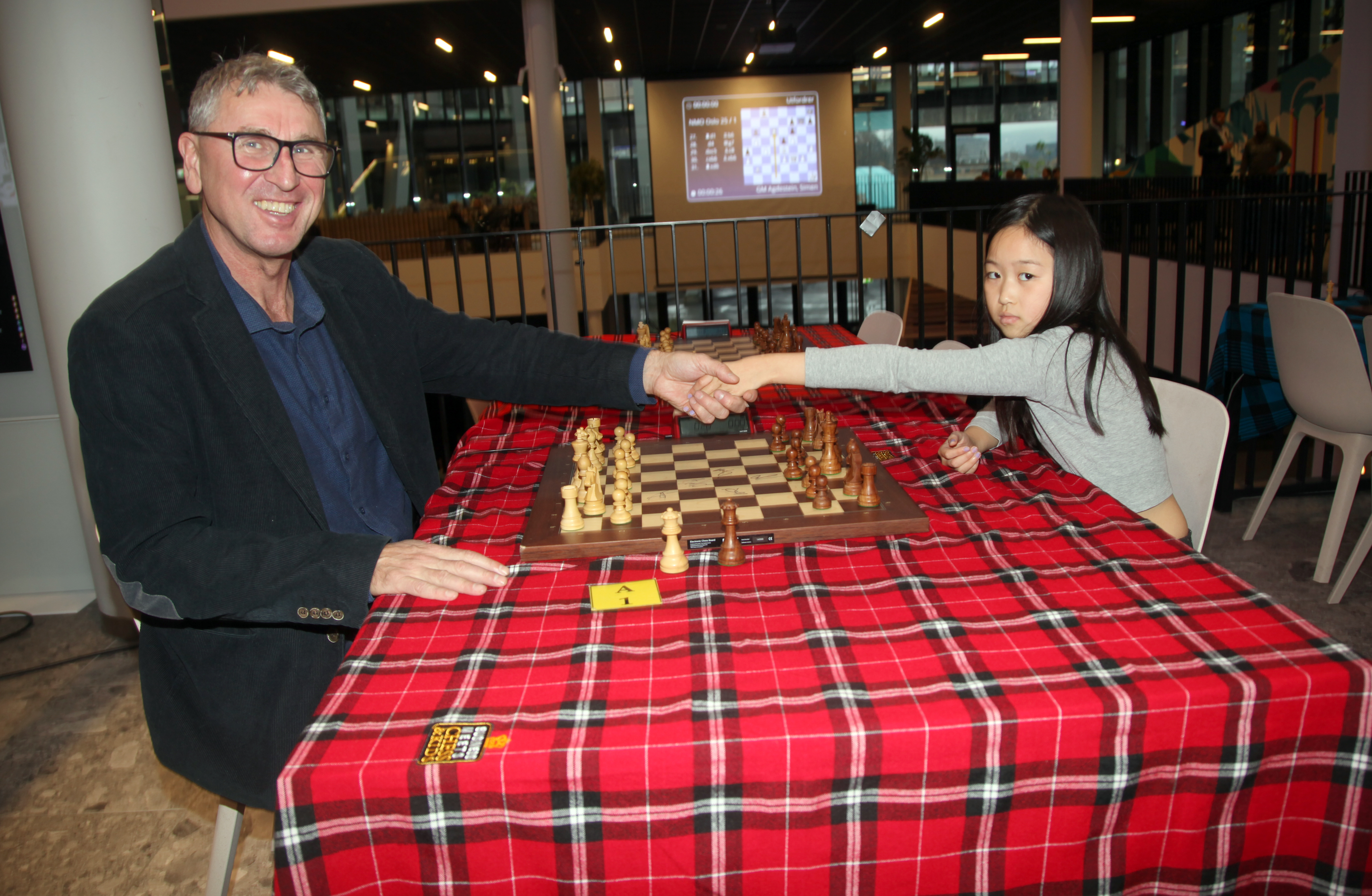 MØTTE MESTEREN: Ella (9) fikk også muligheten til å spille mot Simen Agdestein i en oppvarmingskamp, men måtte gi tapt. Simen spiller for fullt for å vinne, hvis ikke er det å lure unge talentfulle spillere. Men Ella viste hva hun er god for ved å nå finalen i parsjakkturneringen sammen med stormester Olga Dolzhykova. 