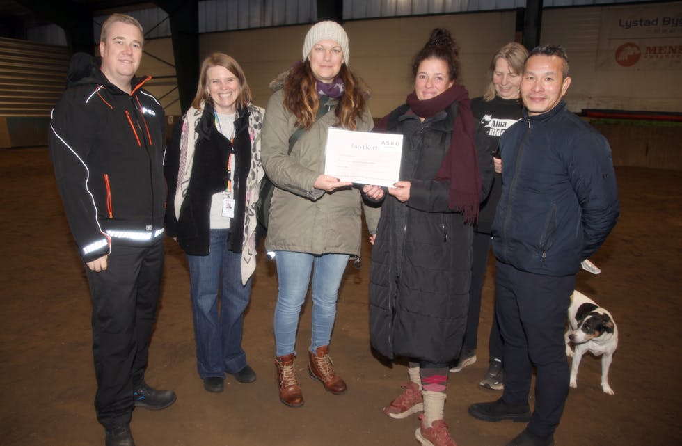 BLIDE FJES: Prosjektleder Christoffer Aaser (f. v.), HR-leder Ida Elisabeth Rognlid, lagerarbeider Petra Winberg og lagerarbeider Luan Nguyen (t. h.) i ASKO, overrekker 20.000 kroner til frivillig Milli ved Alna Ridesenter. Daglid leder Lene Kragh ved ridesenteret har også all grunn til å smile, mens områdesjef og gårdshunden Kvik, som alltid får med seg det som skjer, selvsagt hadde full kontroll også ved denne anledningen.